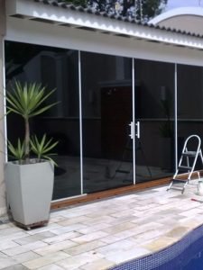 Foto de casa com piscina sem cobertura com instalação de película de proteção solar na porta de vidro